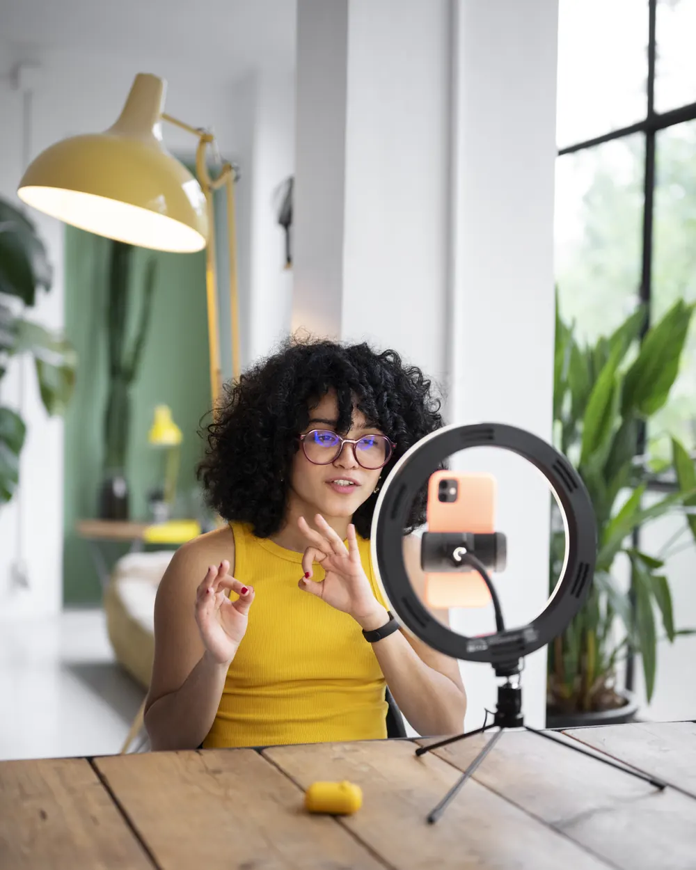 A creator recording a video on her phone with a ring light